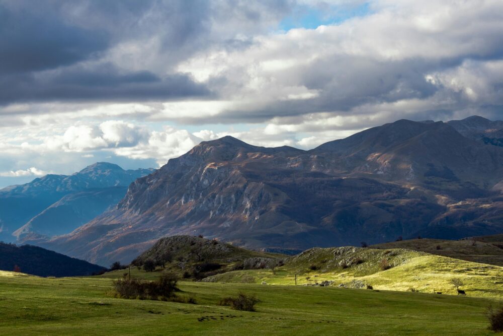 A landscape picture of a mountainous area, with lush grasslands.