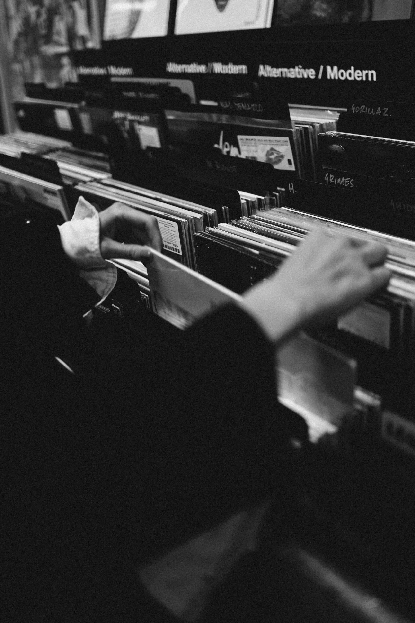A picture of a person browsing through vinyls at a record store.